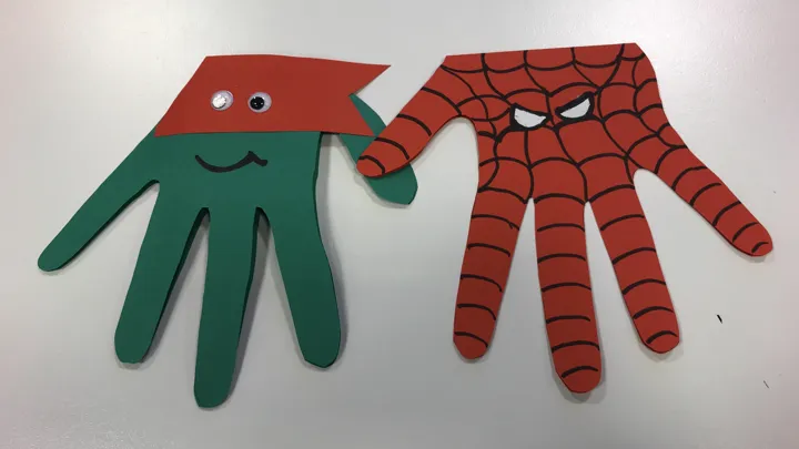 Papirfigurer laget av "utklipt hånd-mønster" og dekorert som superhelter. Foto