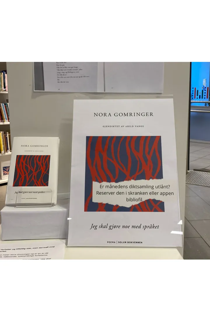 Boka "Jeg skal gjøre noe med språket" av Nora Gomringer står utstilt på et bord sammen med en plakat der det står: Nora Gomringer. Gjendiktet av Arild Vange. "Jeg skal gjøre noe med språket". Er månedens diktsamling utlånt? Reserver den i skranken eller i Bibliofil-appen.