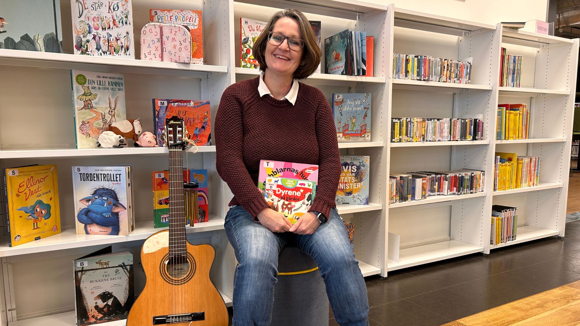 Maskoten GrevLing som leser en bok mens han drar rundt på huset sitt. Illustrasjon