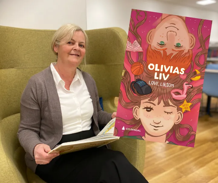 Nina sitter i en lenestol med en bok i hånden. Foto. Omslagsbildet til boka Olivias liv. Love, liksom er satt inn i bildet.