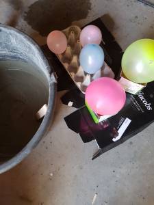 Ballonger blåst opp til forskjellige størrelser står i en eggkartong. Foto