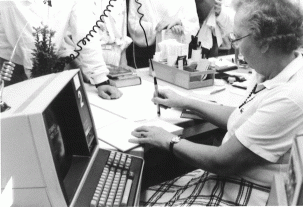 Kontoransatt Julie Torp låner ut bøker med pc og lyspenn. 1985? Foto: Larvik bibliotek.