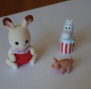 Tre små figurer: en gris, et mummitroll og en kanin med røde bukser. Foto