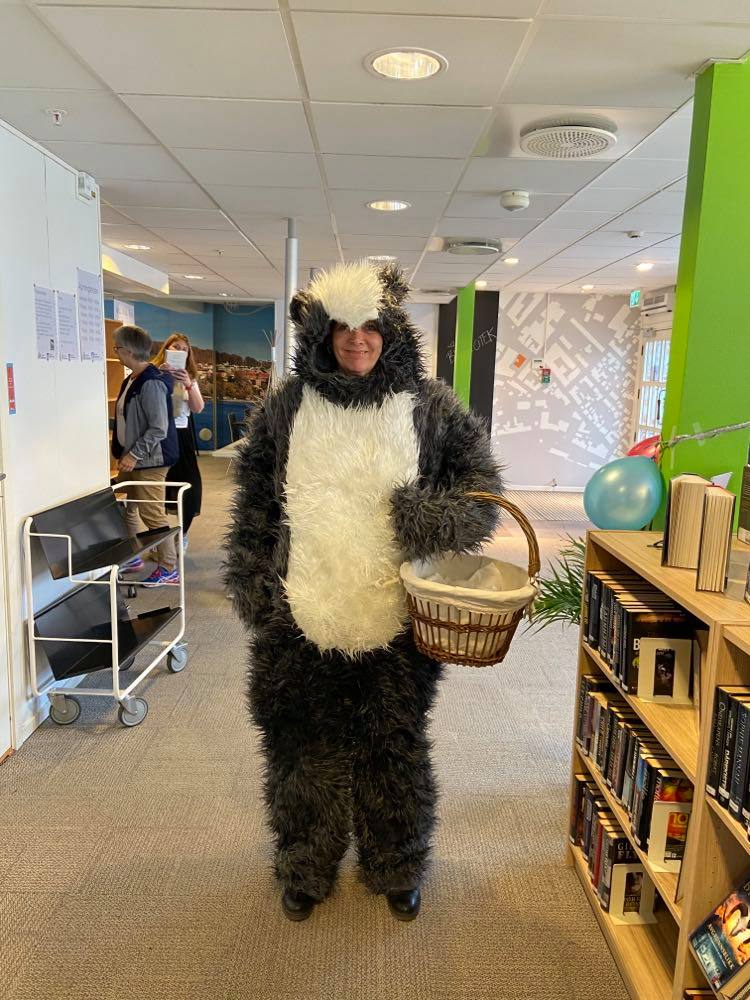 Bibliotekets maskot GrevLing, med en kurv på armen. Foto