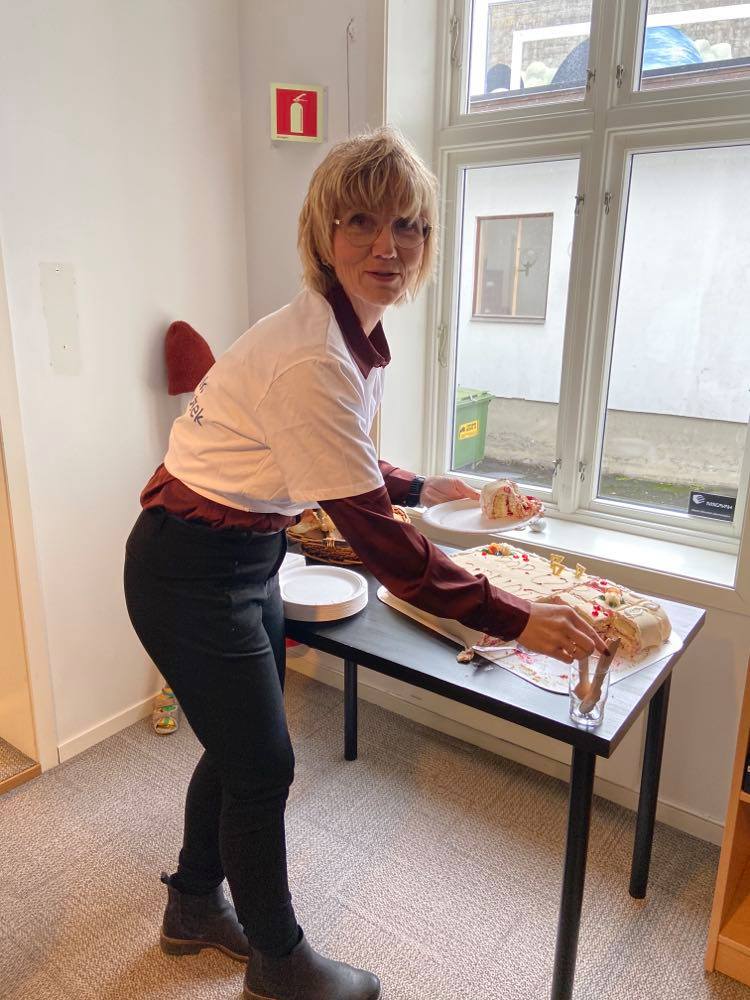 Biblioteksjefen deler ut kake på åpningen. Foto