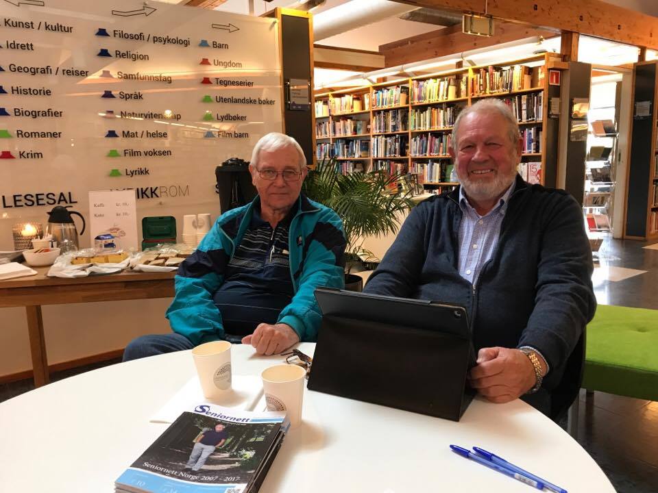 To blide eldre herrer med laptop og kaffe. Foto