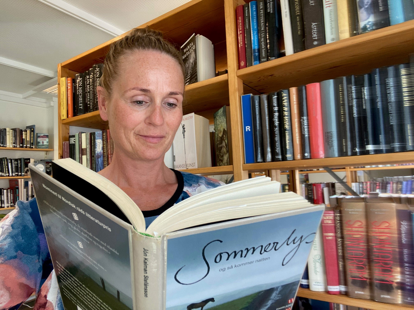 Bibliotekar leser i boka "Sommerlys og så kom natten". Foto