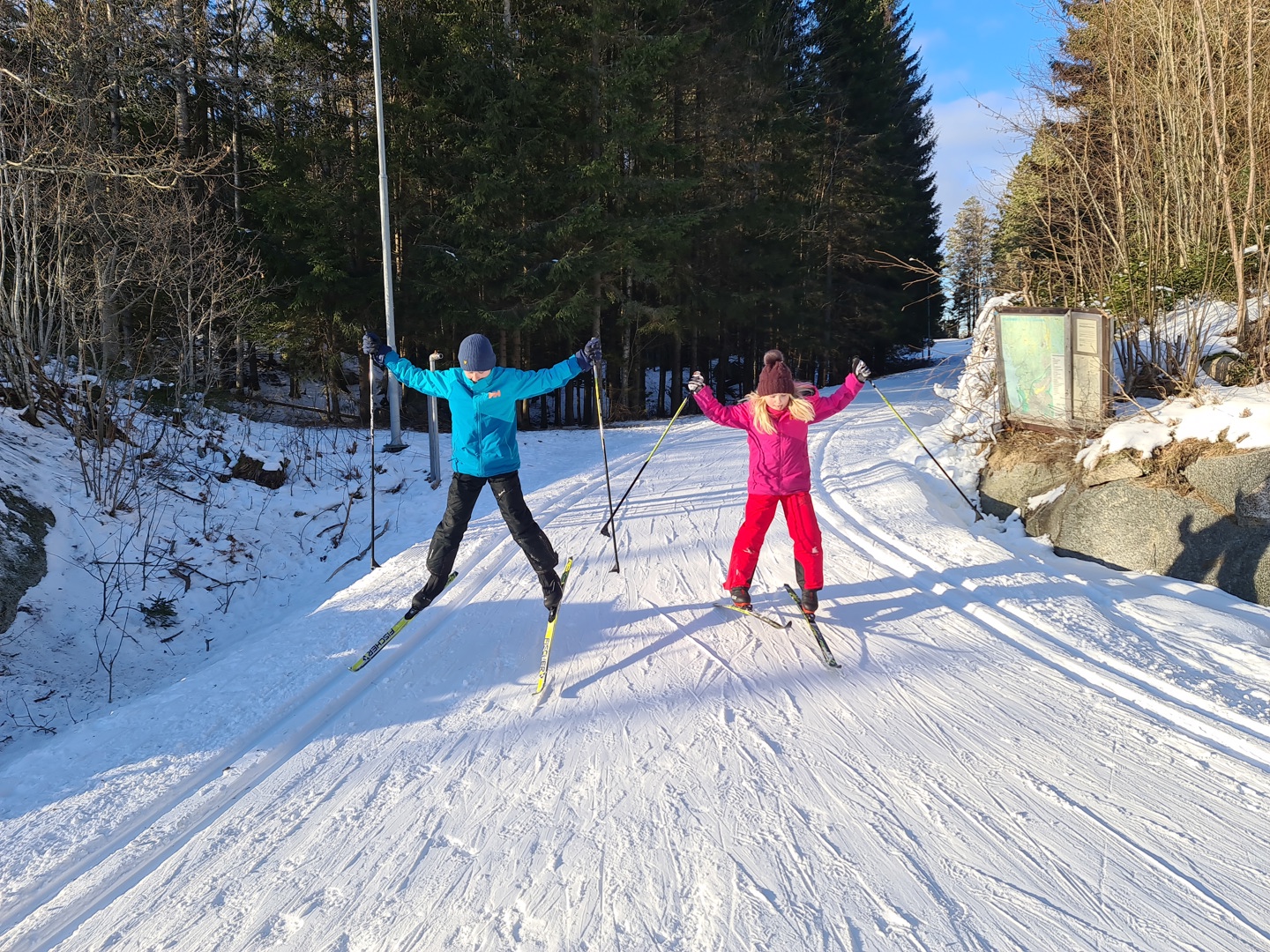 3: Hopp ut i stjerne med armer og ben. To barn gjør dette. På ski. Foto