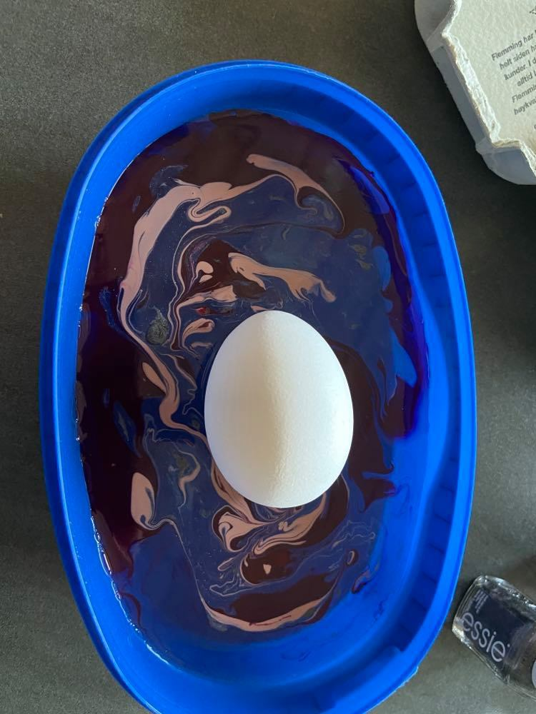 Et egg ligger oppå vannet i en skål. Foto