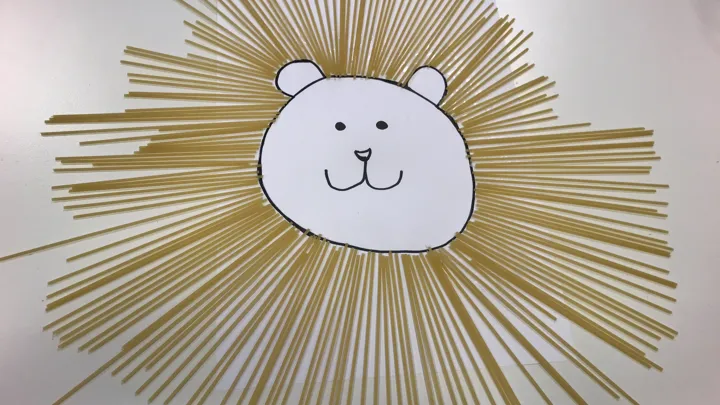 En løve med spaghettikrave. Tegning med pålimt pasta. Foto