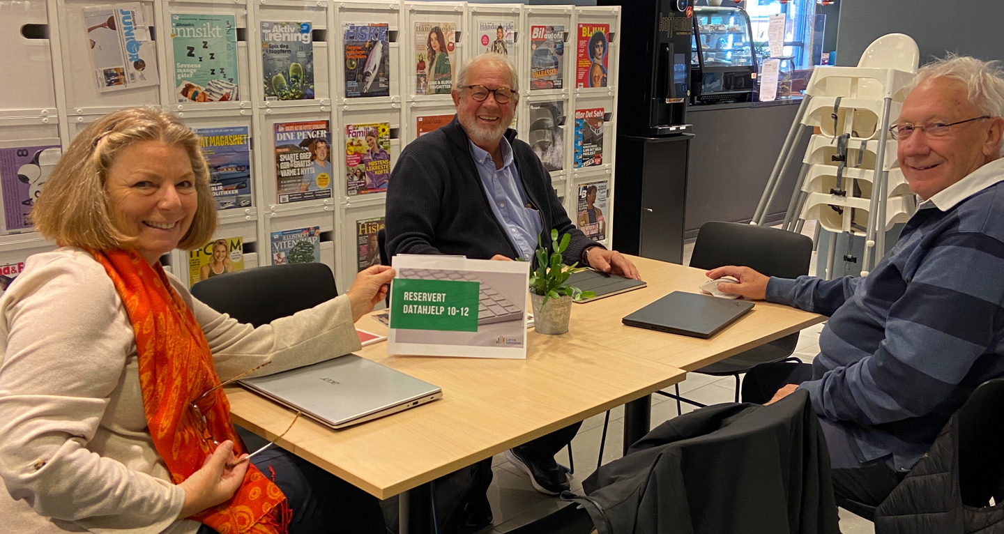 Tre glade veiledere fra Seniornett Larvik: to menn og en kvinne sitter ved et bord med sine pcer. Foto