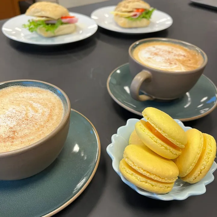 to kopper kaffe, en skål med gule makroner. Foto