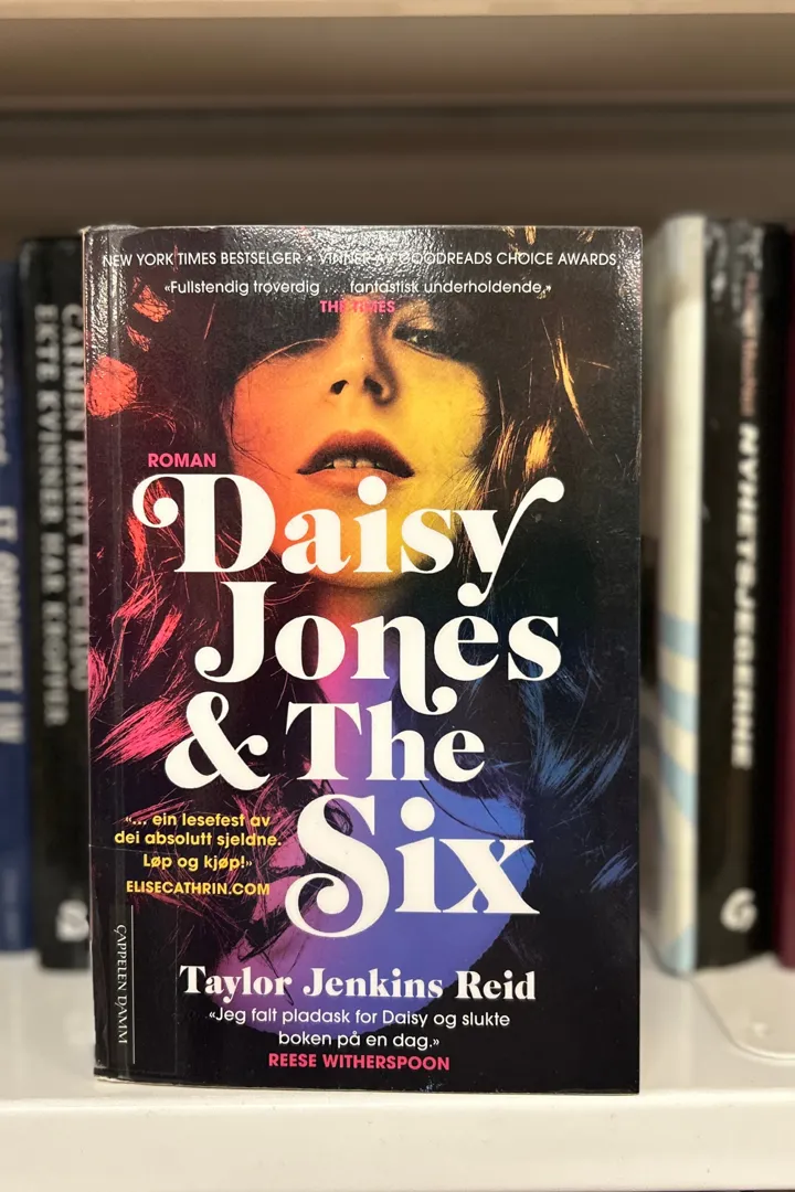 Bokomslag som viser nærbilde av et kvinneansikt. Bokas tittel Daisy Jones & The Six står med store bokstaver over bildet.