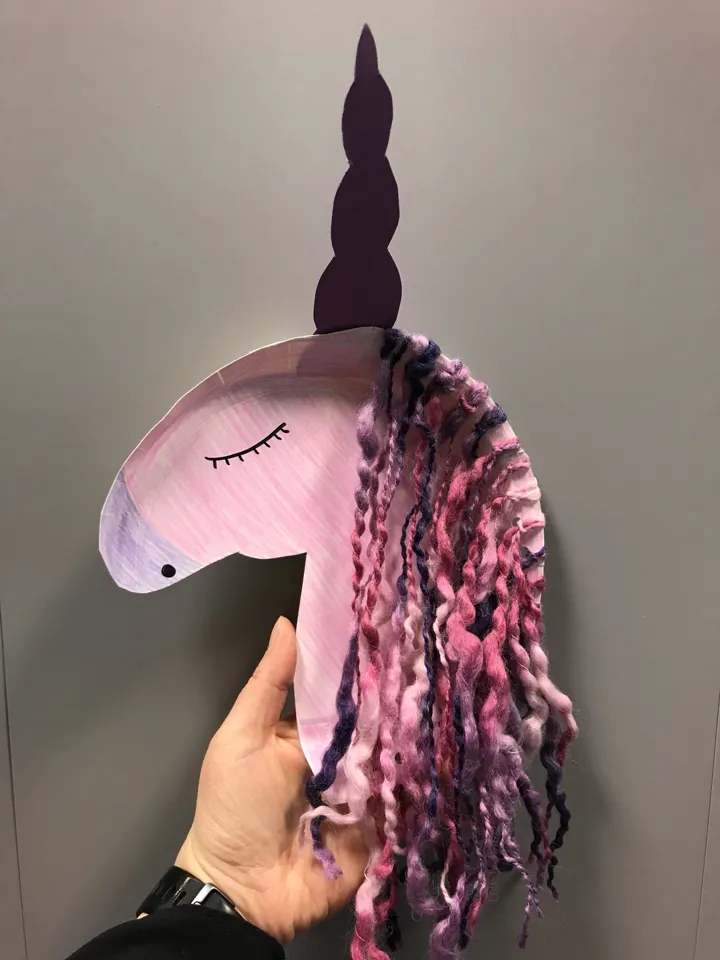 En rosa vakker enhjørning laget av en papptallerken. Den har man av garn i flere blålilla og rosa farger. Foto: Larvik bibliotek