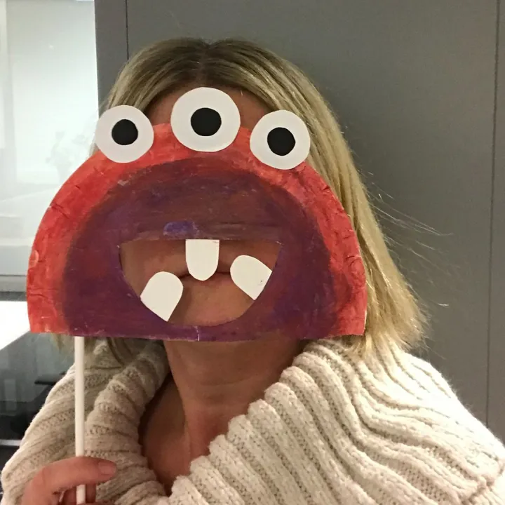 En kvinne med monstermaske foran ansiktet. Foto