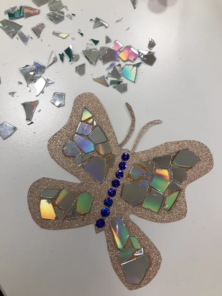 En sommerfugl som er laget av papir og knust CD. Foto