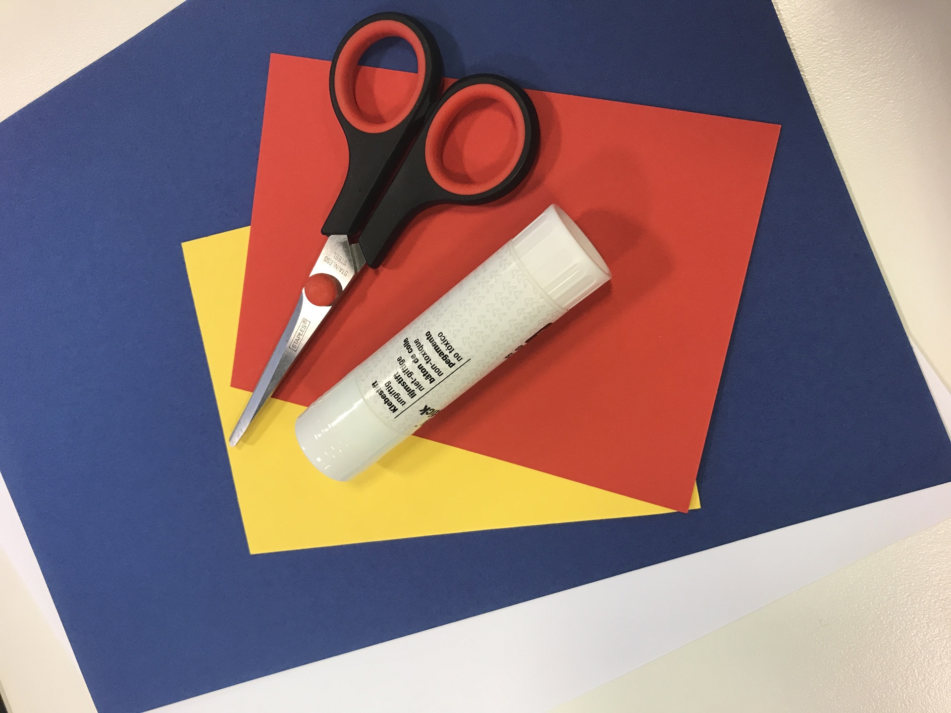 Saks, limstift og farget papir. Foto